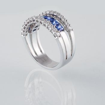 RING, 18K vitguld med 26 briljantslipade diamanter 0.88 ct samt 7 blå safirer 1.36 ct. Vikt 7,8 gram.