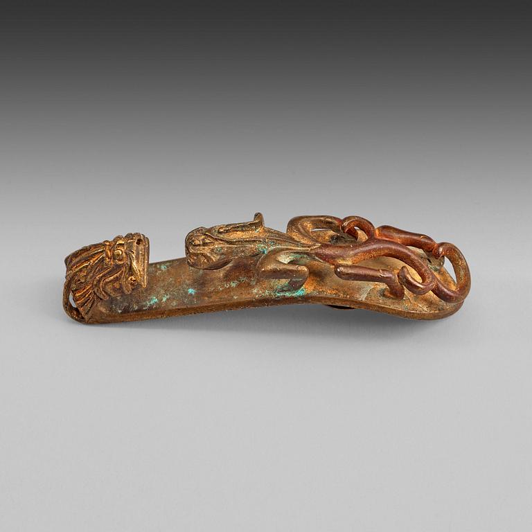 BÄLTESSPÄNNE, förgylld brons. Troligen Han dynastin (206 f.Kr-220).