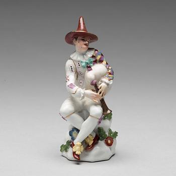 A porcelain figure of harlekin playing the bagpipe, circa 1900.