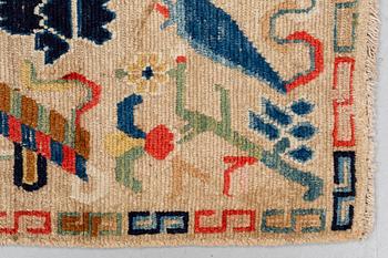 A rug, antique Tibet, ca 71 x 57,5-59 cm (as well as 1,5 cm flat weave at one end).