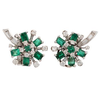455. A pair of 14K white gold, emerald and round brilliant- and baguette cut diamond ear clips.
