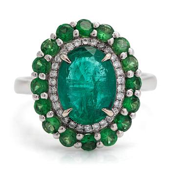 A 14K white gold ring with an emerald  2.33 ct, tsavorites 1.20 ct and diamonds ca 0.14 ct. With IGI certificate.