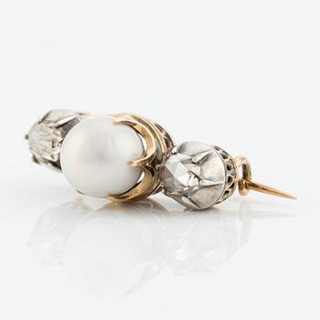 A brooch in silver and gold with a pearl and two rose-cut diamonds.