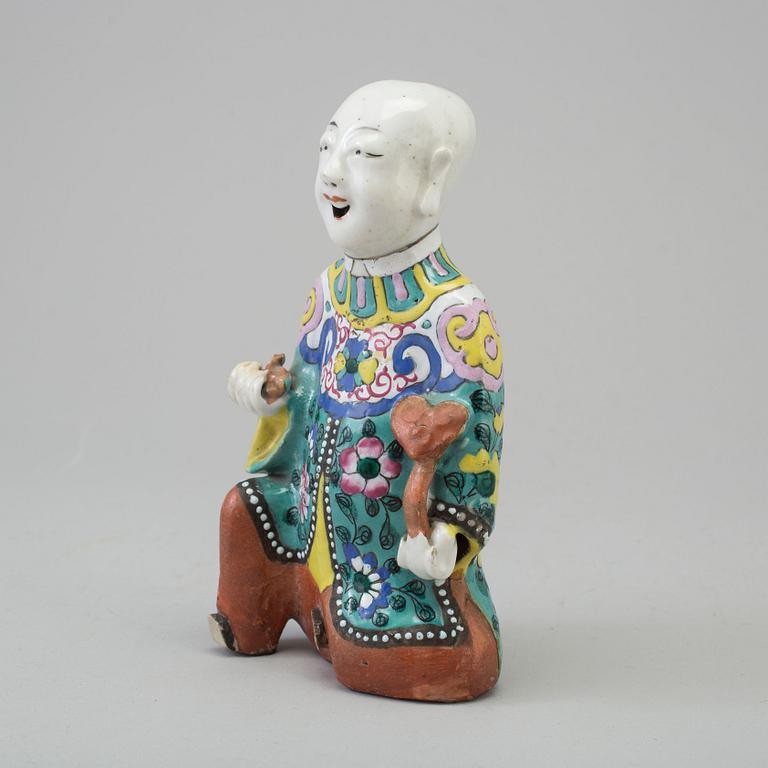 A porcelain figure of a laughing boy, Qing dynasty, 19th Century.