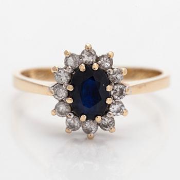 A 14K gold ring, with an oval faceted sapphire and diamonds, England.