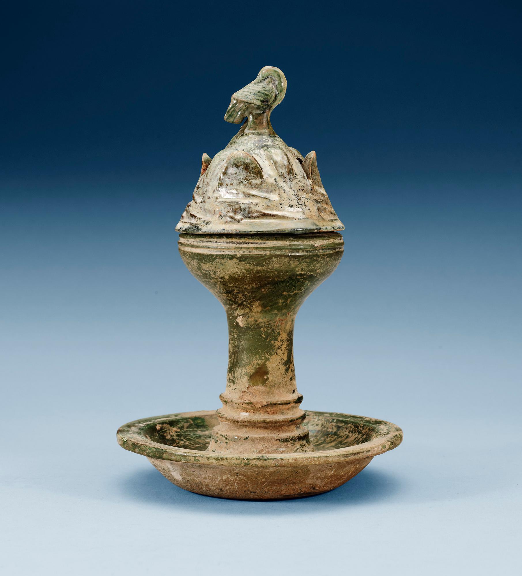 A green glazed pottery Hill Jar, cover with bird shaped finial, Han dynasty (206 BC-AD 220).