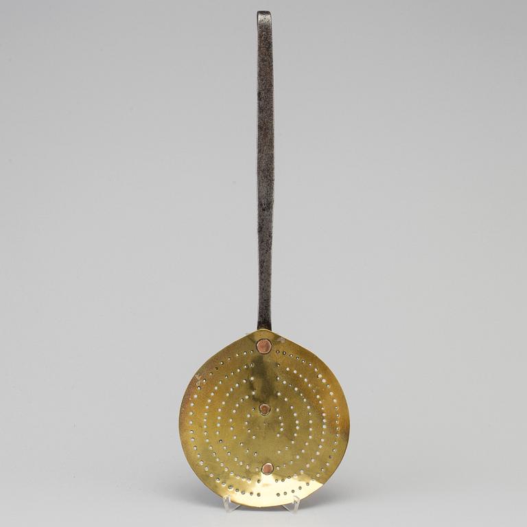 An 18th century iron and brass strainer.