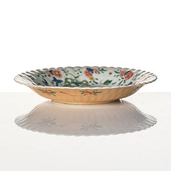 A Chinese iron red porcelain cup with saucer and a small famille verte dish, Qing dynasty, Kangxi (1662-1722).