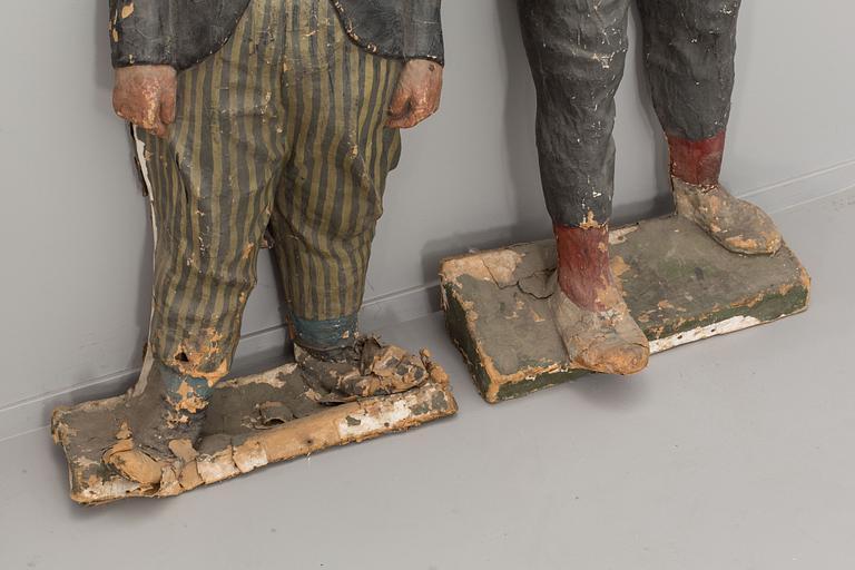 FIGURDOCKOR, ett par, Papier maché,  föreställande Fyrtornet och Släpvagnen. 1900-talets första hälft.