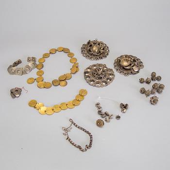 A collection of mostly silver, tradition folk buttons and belt buckles.