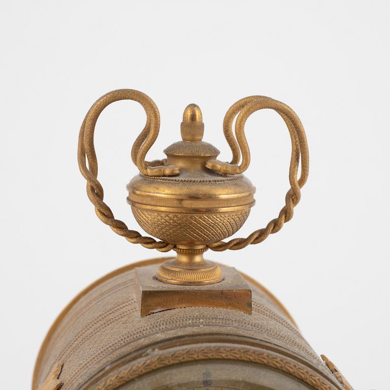 An Empire-style gilt bronze mantel clock and a pair of candlesticks, 20th century.