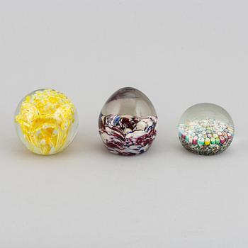 A group of 12 glass paper weights.