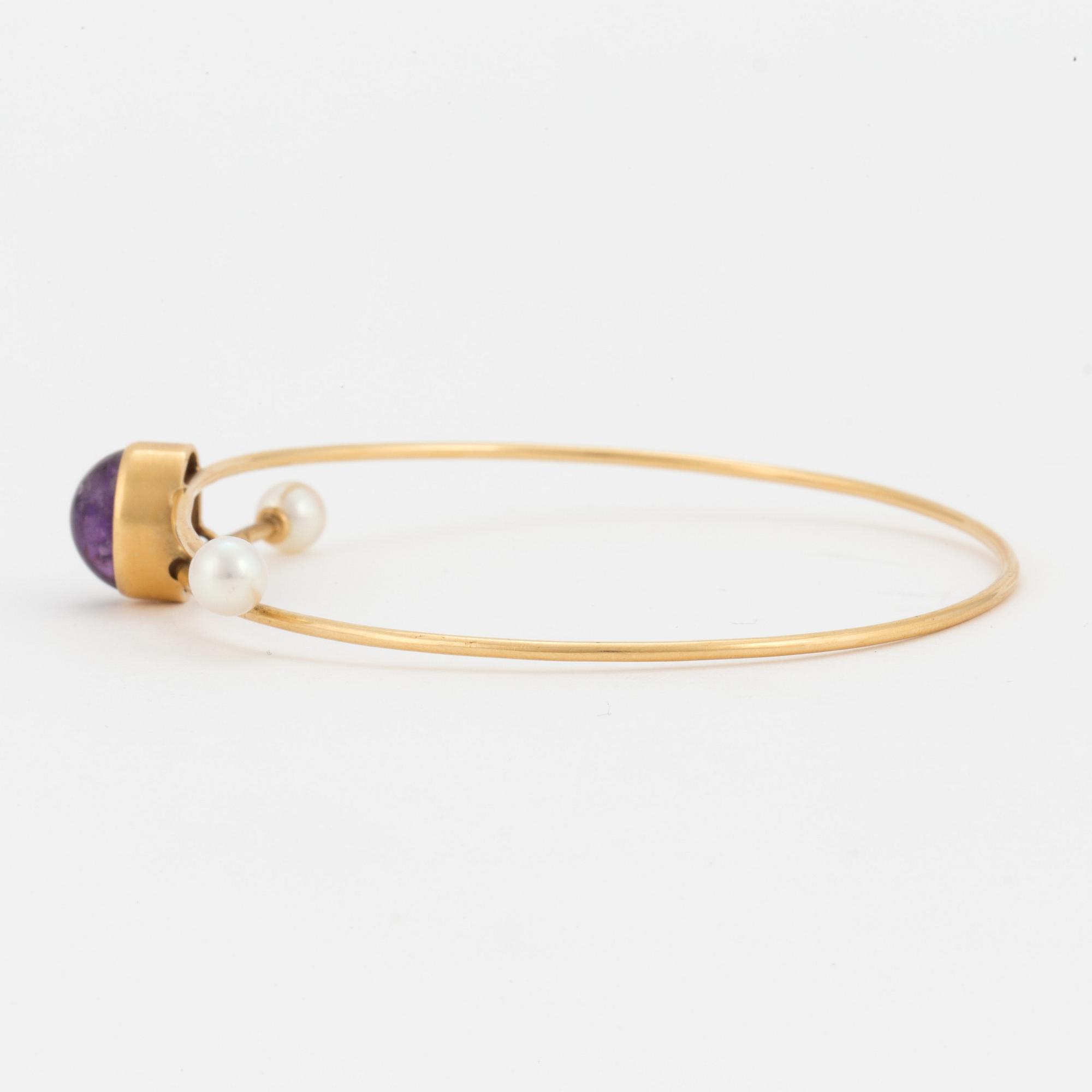 A bangle set with a cabochon-cut amethyst and cultured pearls.