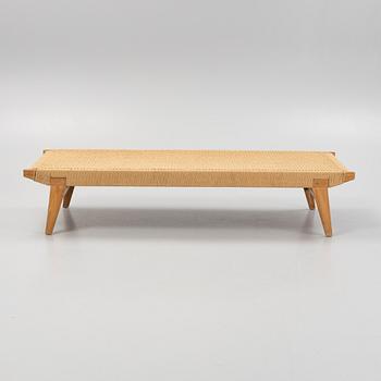 A contemporary teak daybed.