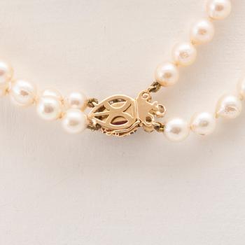 A double-stranded necklace with cultured pearls and an 18K gold clasp with a faceted synthetic ruby and old-cut diamonds.