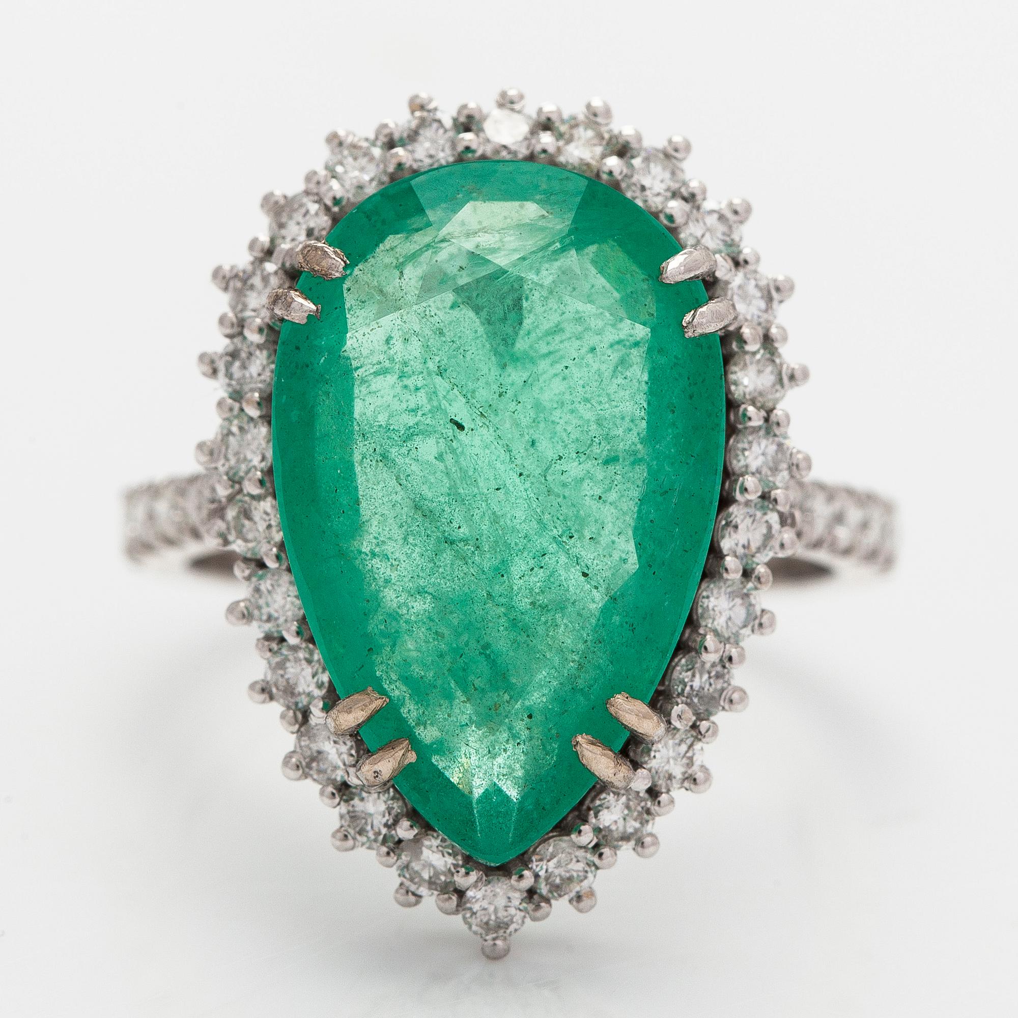 A 14K white gold ring, with a pear-cut  emerald ca. 7.72 ct and diamonds.