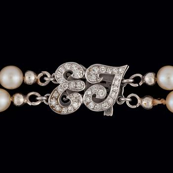 34. A 2-strand cultured pearl necklace. Clasp in the shape of the letters 'EJ' set with brilliant-cut diamonds.