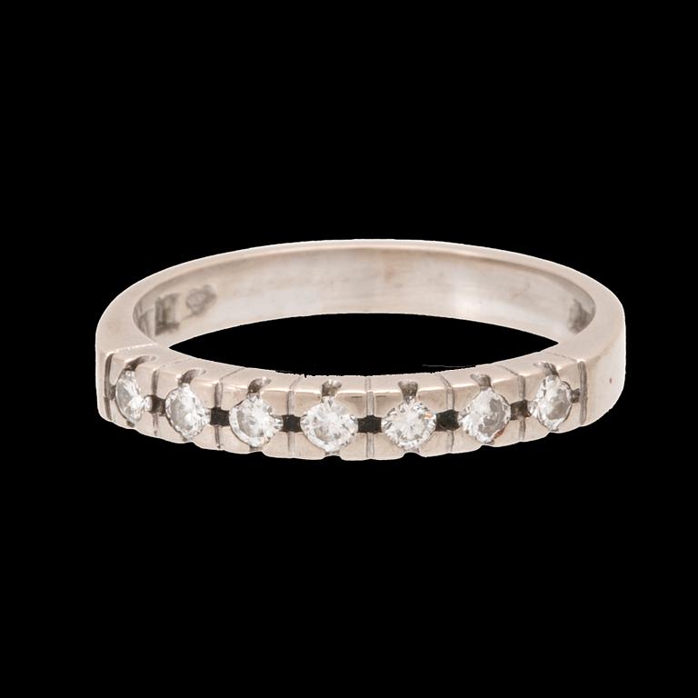 A half eternity ring in 18K white gold set with round brilliant-cut diamonds.