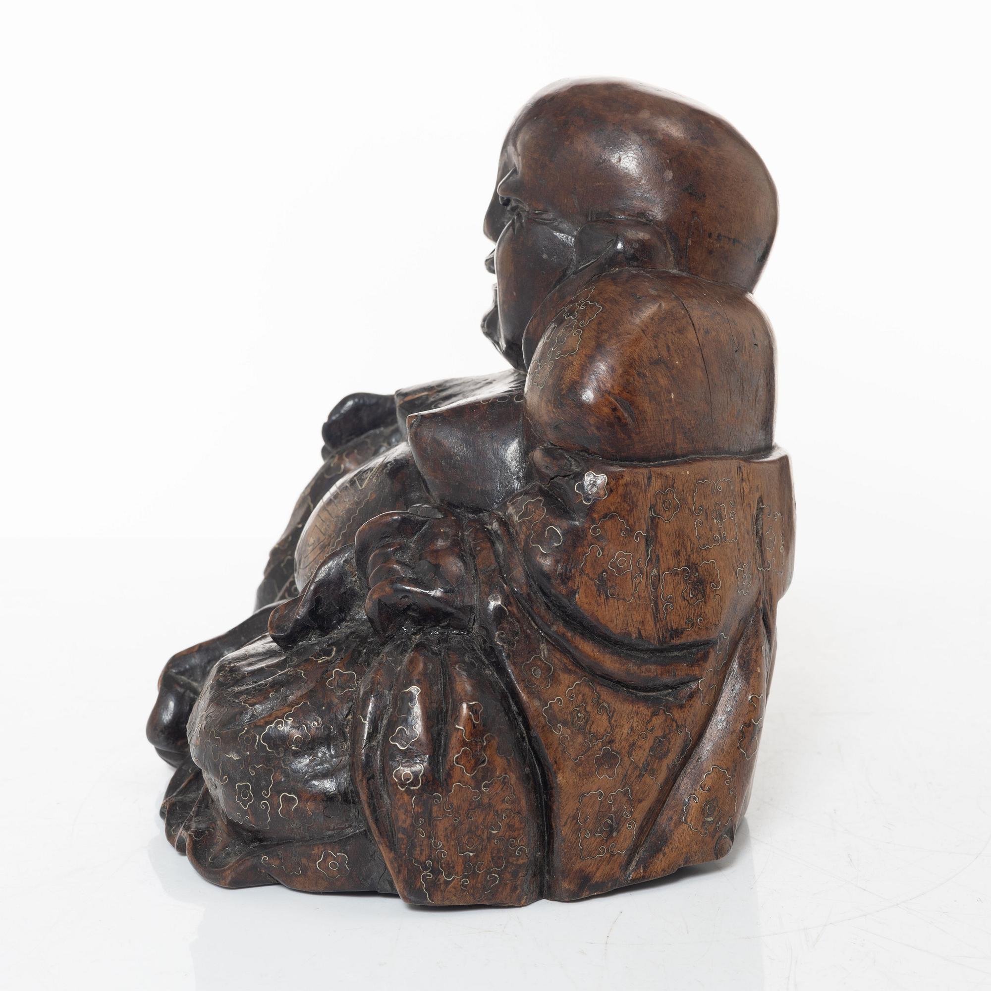 A Chinese wooden figure of Budai with silver inlays, Qing dynasty (1644-1912).