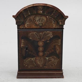 A hanging cabinet, dated 1870.