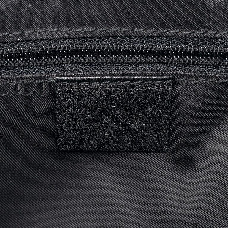 Gucci, a black leather handbag.