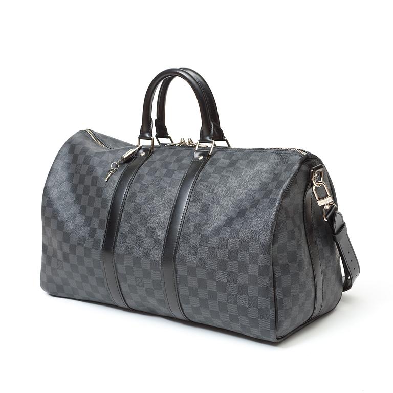 A black damier ebene canvas weekend bag by Louis Vuitton.