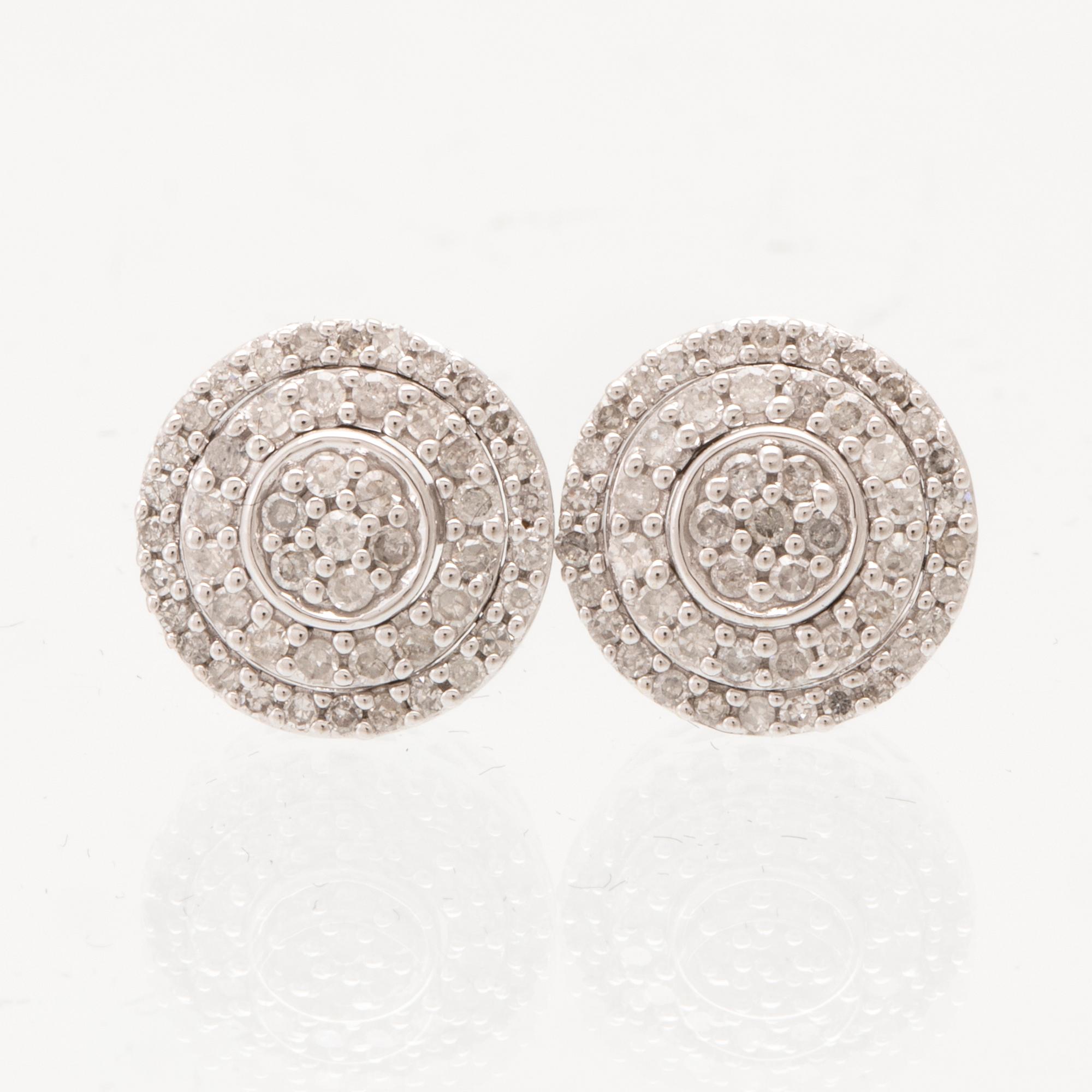 A pair of 14K white gold earrings set with round single-cut diamonds.
