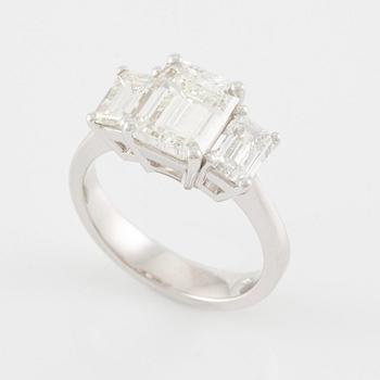 An 18K white gold ring set with three emerald-cut diamonds.