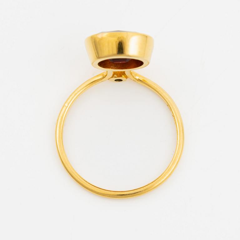 Ring in 18K gold with an oval faceted garnet and a brilliant-cut diamond.