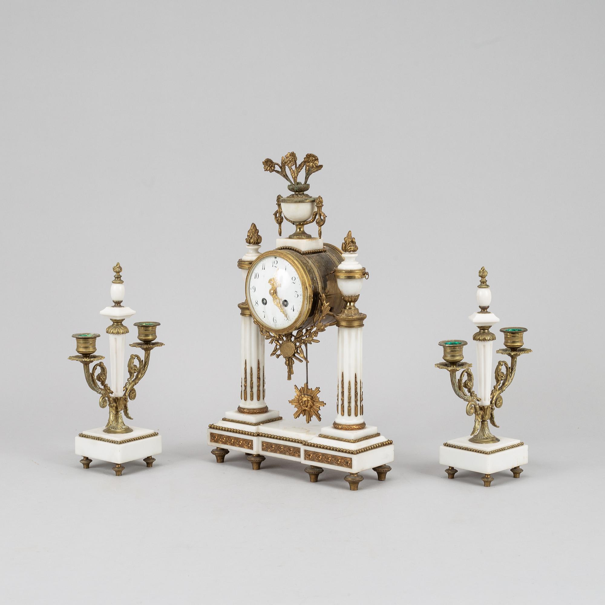 A Louis XVI style pendulum clock and a pair of candelabra, early 20th century.