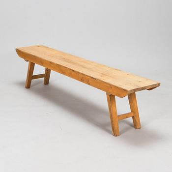 A wooden bench with folding legs from the first half of the 20th century.