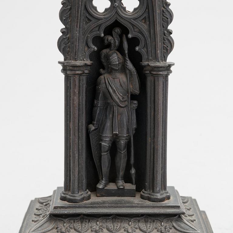 A neo-gothic cast iron pocket watch stand with a pocket watch. 19th century.