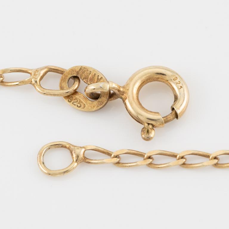 Pendant in 18K gold with a cultured pearl and faceted white stones.