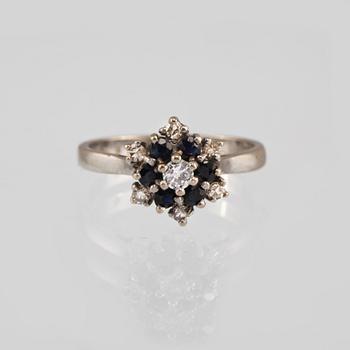 RING, 18K vitguld med en briljantslipad och 6 åttkantslipade diamanter och 6 fasettslipade blåsafirer. Vikt 3,9 gram.