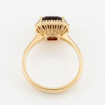 Ring in 18K gold with a faceted garnet and round brilliant-cut diamonds.