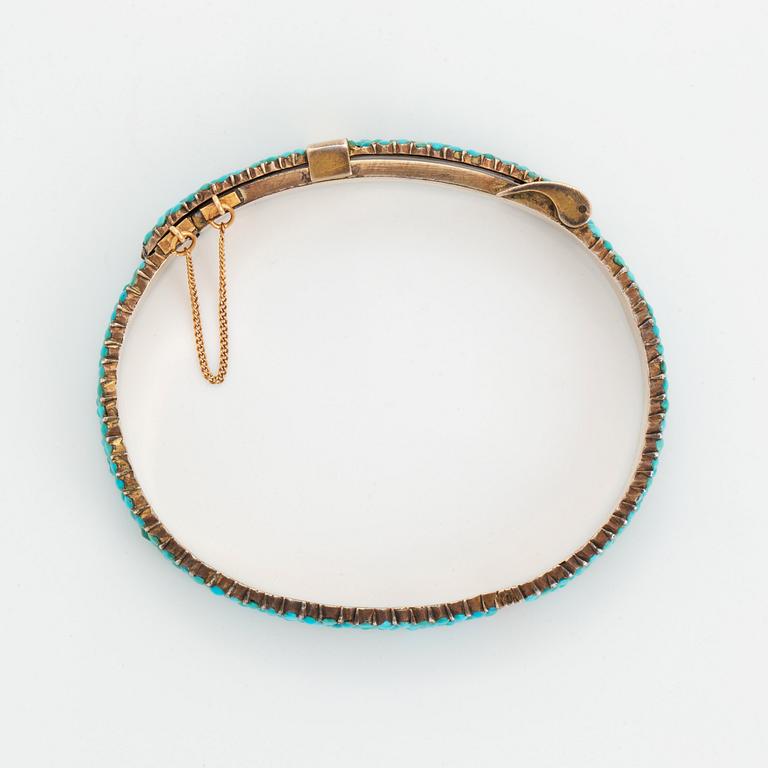 A silver and turquoise bracelet.