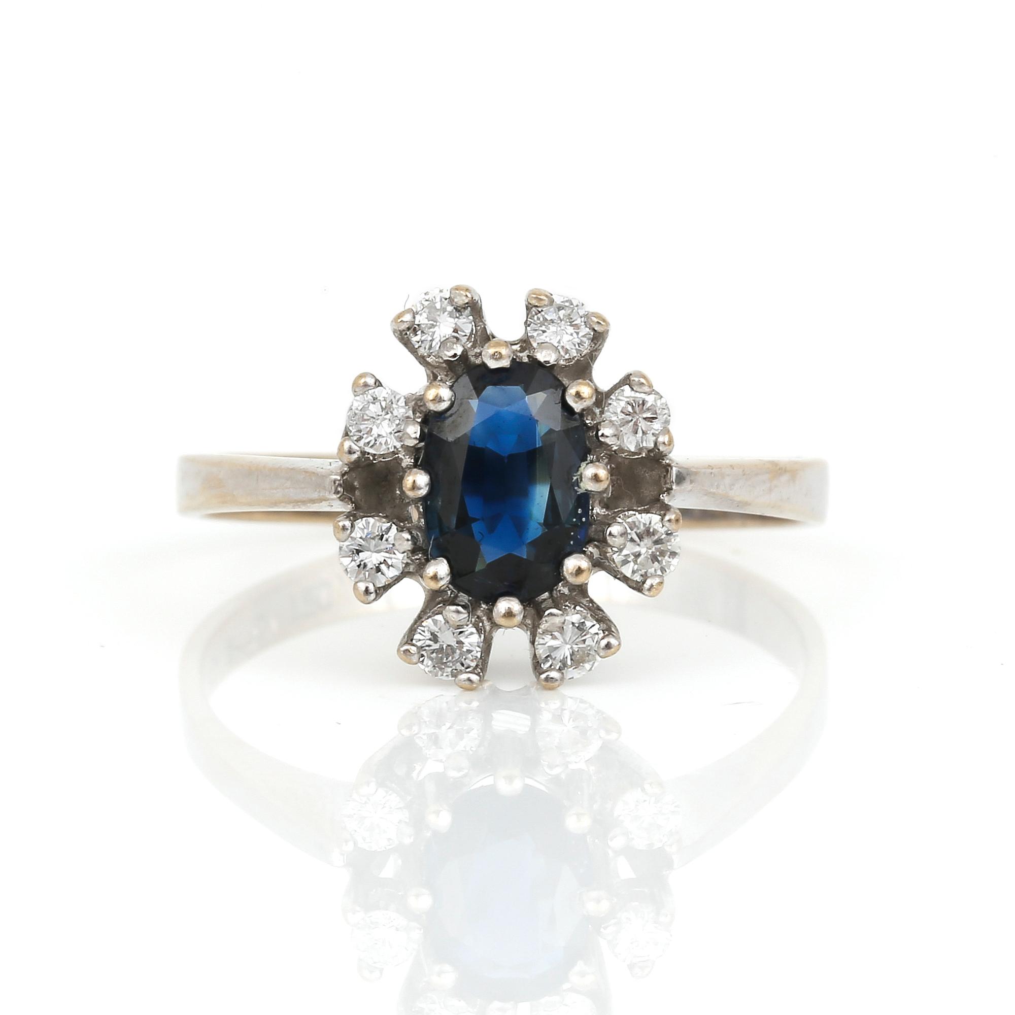 RING, 18K vitguld med ovalslipad safir ca 0,29 ct och briljantslipade diamanter tot ca 0.20 ct. Vikt ca 3,25 g.