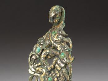 An archaistic silver gilt bronze garment hook inlayed with green stone,