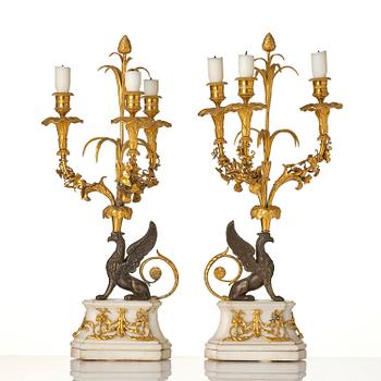 A pair of three-light Louis XVI patinated and ormolu candelabra in the manner of François Rémond, late 18th century.