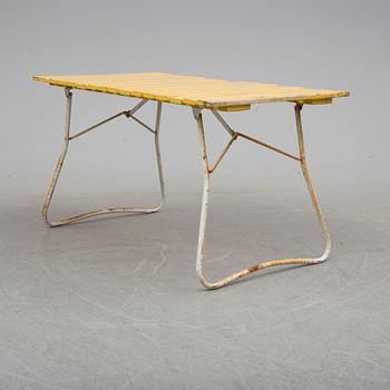 A mid 20th century garden table and three chairs.