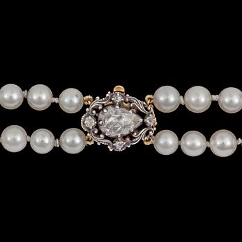 1087. A two strand cultured pearl necklace, 7,4 mm, rose cut diamond clasp.
