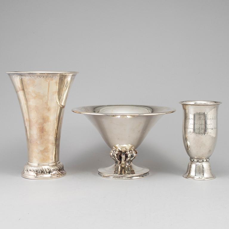 Two silver beakers and a bowl.