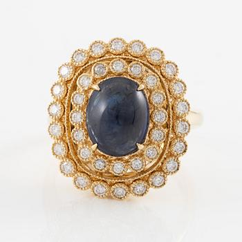 Ring in 18K gold with cabochon-cut sapphire and brilliant-cut diamonds.