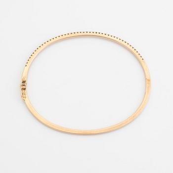 An 18K rose gold bangle set with round brilliant-cut diamonds.