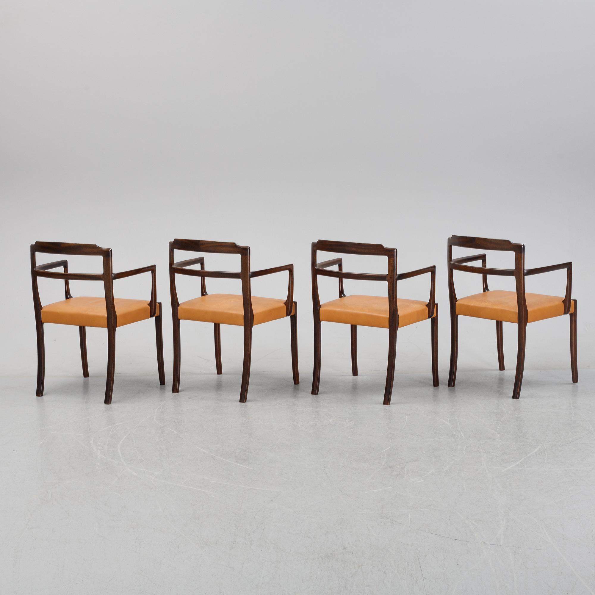 A set of four black stained beech tree arm chairs with leather upholstery, second half of the 20th century.