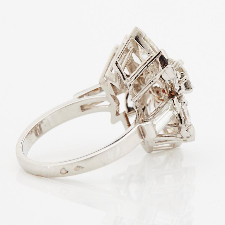 A platinum ring set with round brilliant-, navette- and baguette-cut diamonds.