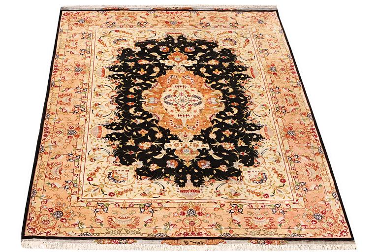 A Tabriz rug, part silk, 50 raj, a. 210 x 147 cm.