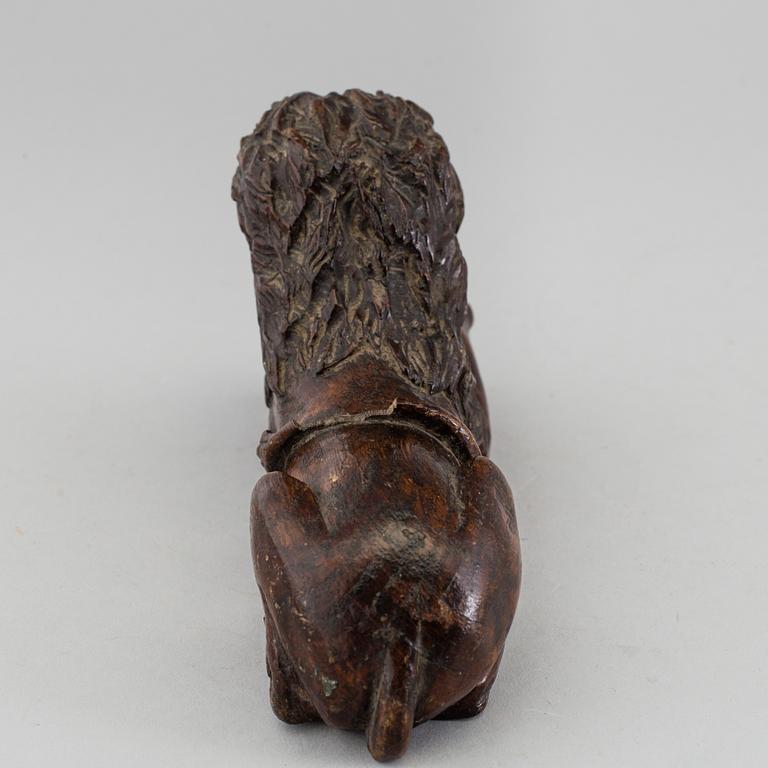 A 17TH CENTURY CARVED WOOD FIGURE OF A LION.