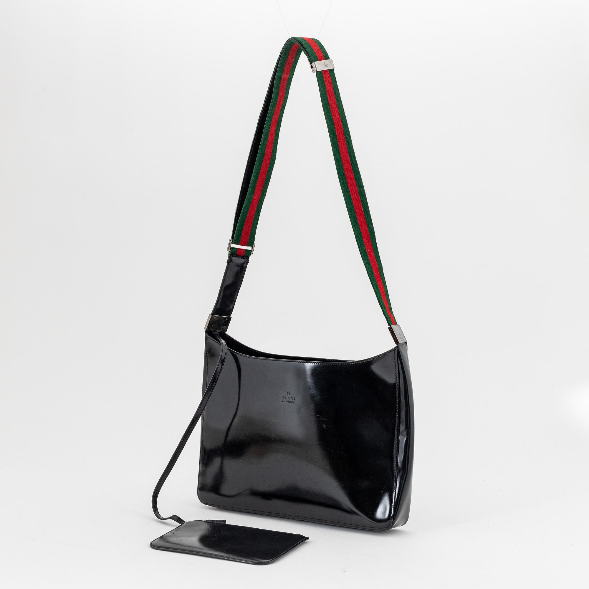 Gucci, a black, patent leather handbag.