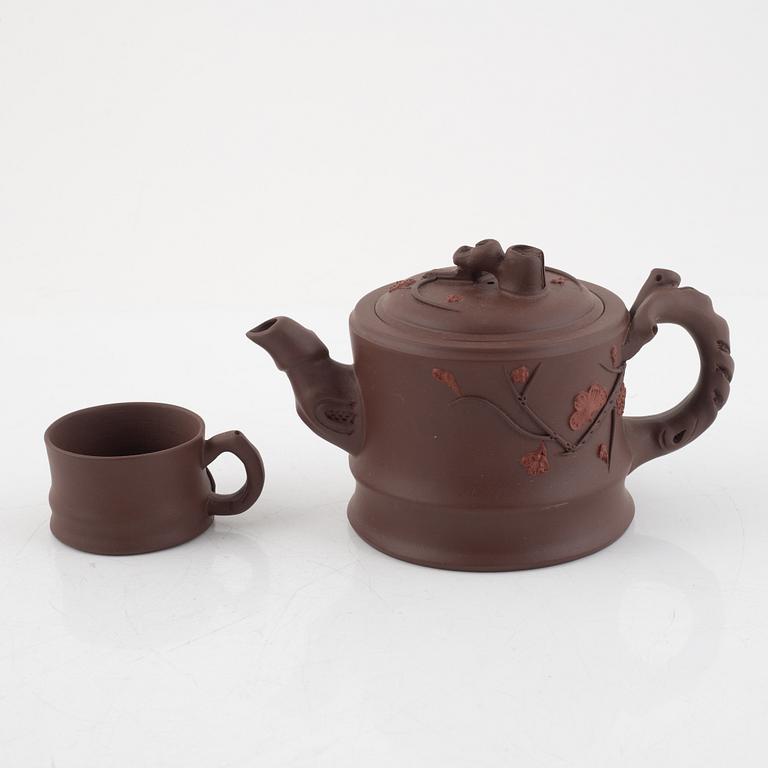 A Chinese yixing ware teapot with four cups, 20th century.